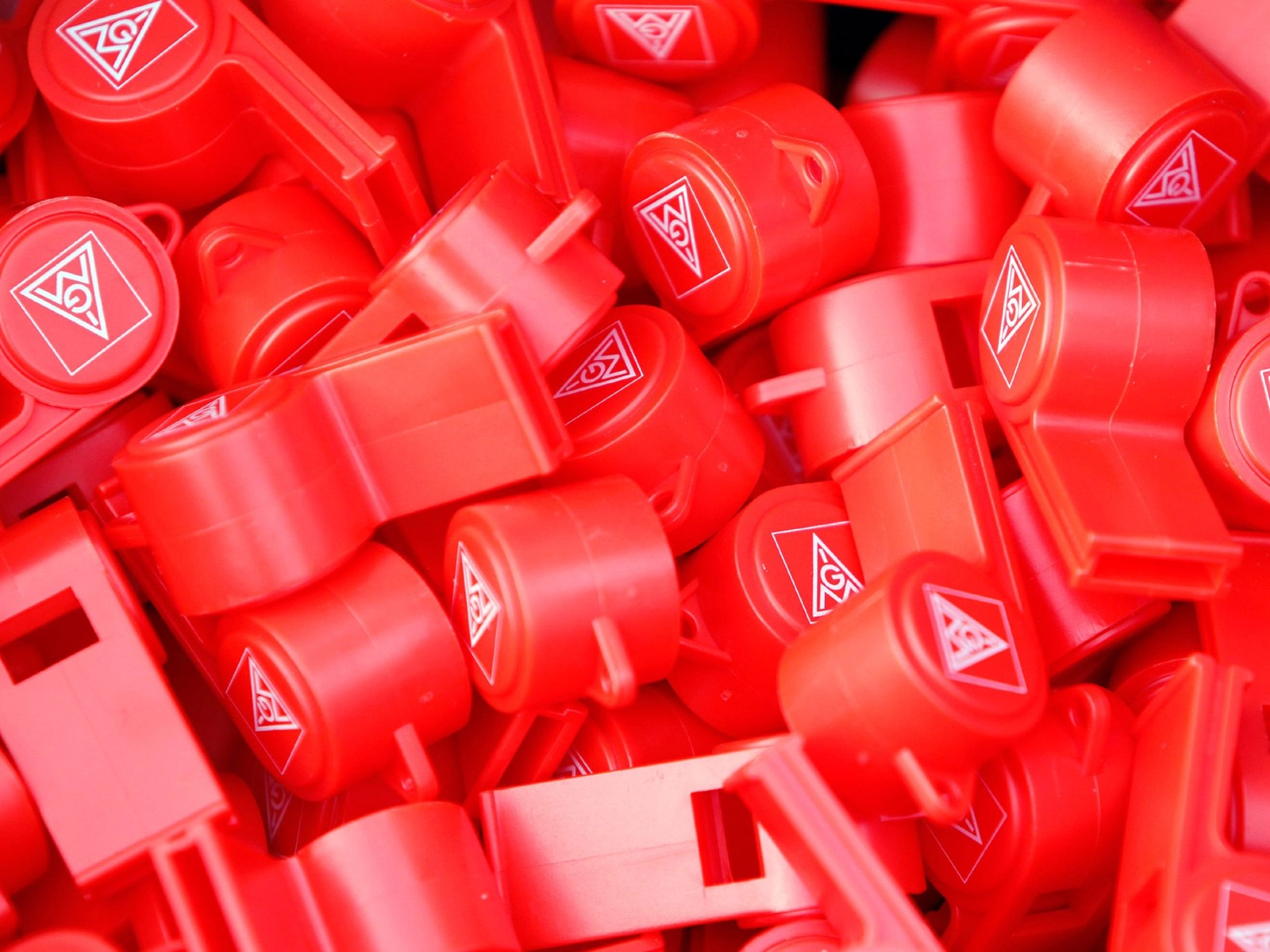 Viele roter Trillerpfeifen mit dem IG Metall Logo.